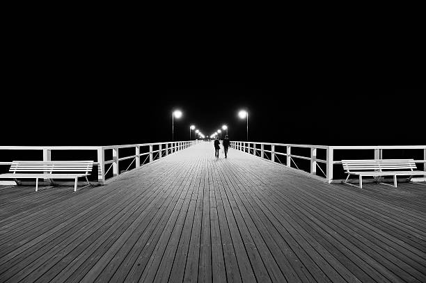 istock Benches and lamp posts on a pier at night. 531658399