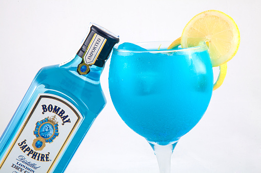 Valencia, Spain, october 31, 2013: A Bottle Of Bombay Sapphire Gin Isolated On A White Background, with a glass with ice and lemon