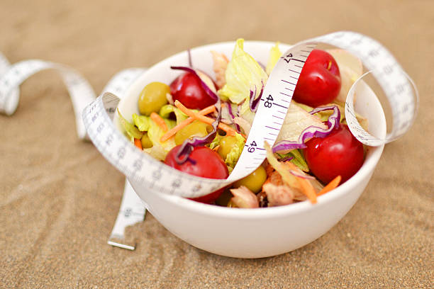 istock salad and tape measure on sand 531671753