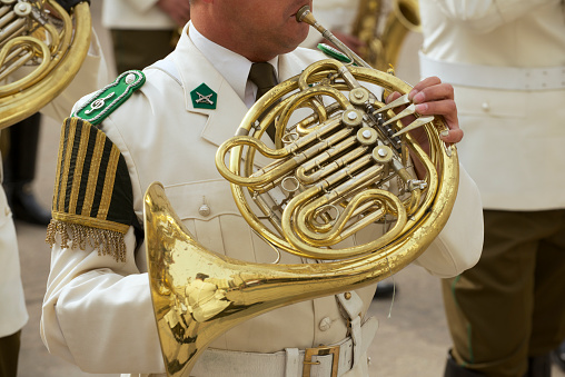 Close-up view of musicians playing trombones. Focus on the foreground, trombone bell.