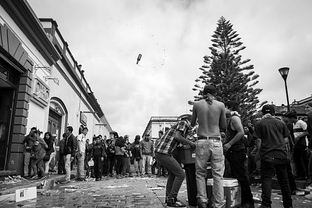 San Cristobal de las Casas, Mexico - November 20, 2014: A beer bottle twirls through the air as looters clean out an OXXO convenience store in San Cristobal de las Casas, Mexico. This day demonstrations where held across Mexico to protest the government's handling of and involvement in the disappearance of 43 students on September 26, 2014 in Iguala.