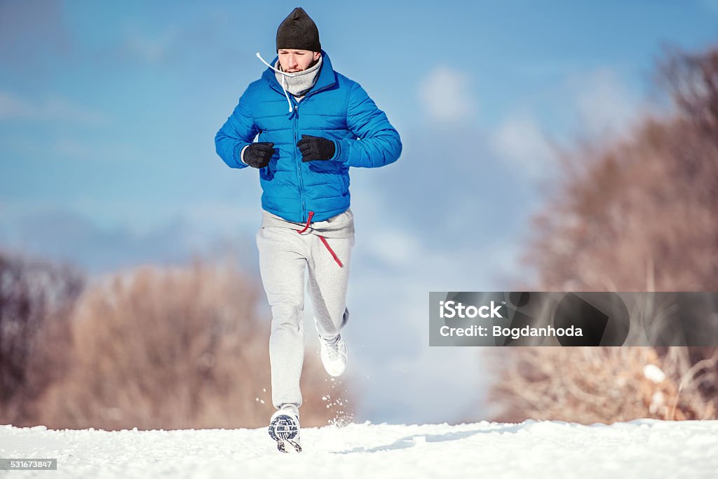 Fitness concept of a man running outdoor in snow Fitness concept of a man running outdoor in snow on a cold winter day 2015 Stock Photo