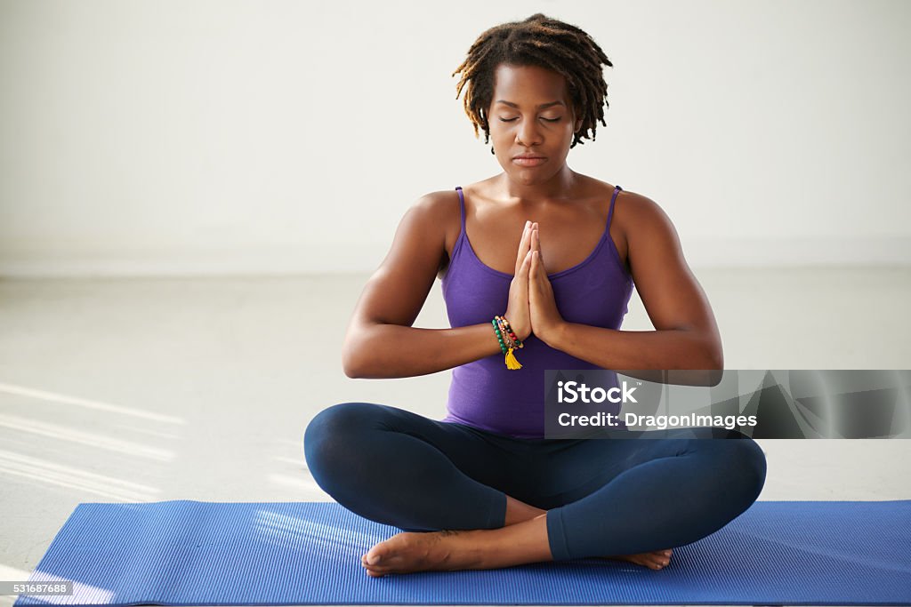 Meditating woman African-American woman meditating in lotus position African Ethnicity Stock Photo