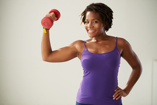 Portrait of fir woman posing with dumbbell