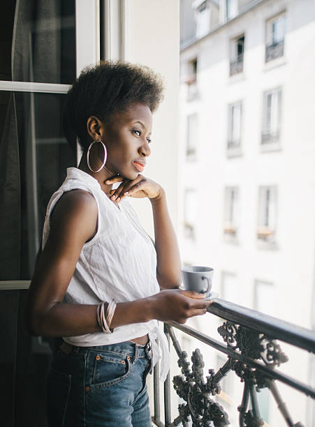 istock Woman relaxing with a cup of coffee besides the window 531691154