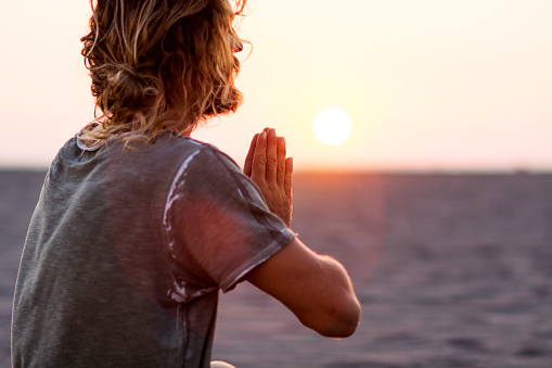 Man doing yoga at the beach