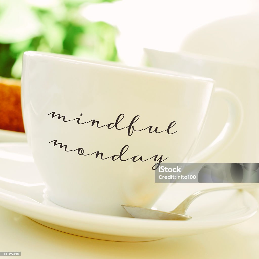 cup of coffee or tea with the text mindful monday closeup of a cup of coffee or tea on a set table with the text mindful monday written in it Mindfulness Stock Photo