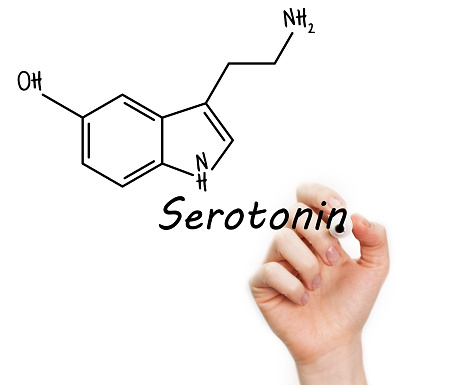 Human had writing word serotonin and chemical formula
