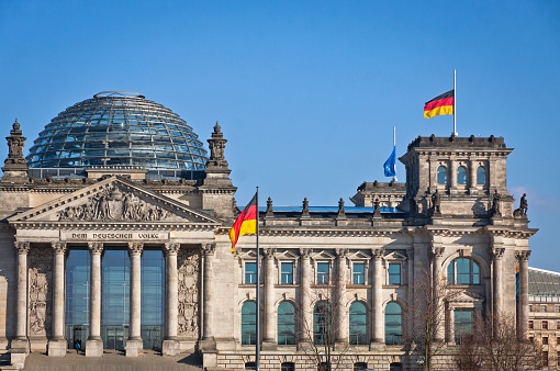 German National flags waving in front of German parliament buildi