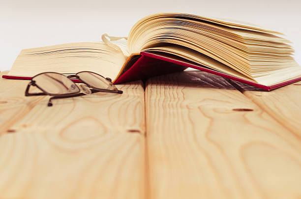 istock Book and glasses on wooden table 531695130