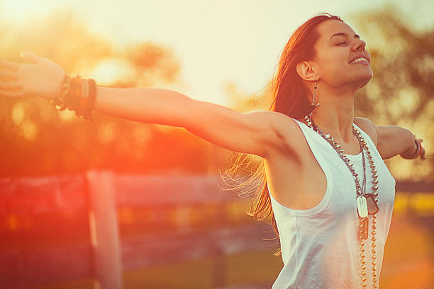 Young woman outstretched arms enjoys the freedom and fresh air stock photo