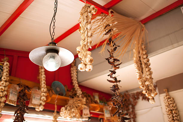 ajo y pimientos cuelgan del techo en el mercado. - garlic hanging string vegetable fotografías e imágenes de stock