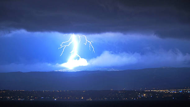 istock Lightening Striking Hills Above Town at Night 531696502