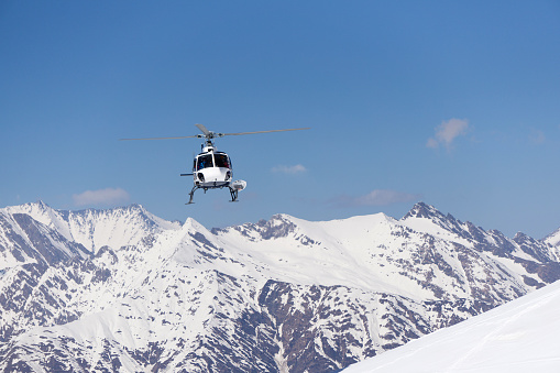 White rescue helicopter in the snowy mountains