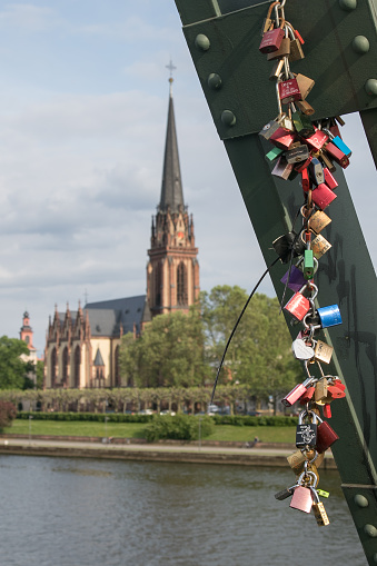 Lovelocks on the Eiserner Steg Bridge in Frankfurt, Germany with the Three Kings Church on the background