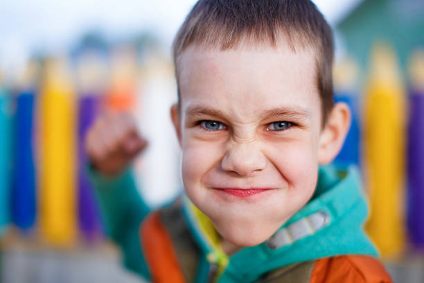 aggressive child raised his fist to strike boy contorted with anger face fighting. selective focus schoolyard fight stock pictures, royalty-free photos & images