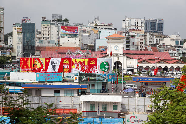 Ho Chi Minh City, Vietnam – January 19, 2016: Central part of Saigon with a large propaganda posters celebrating the 12th congress of the Vietnamese communist party and its founder Ho Chi Minh together with advertisements 