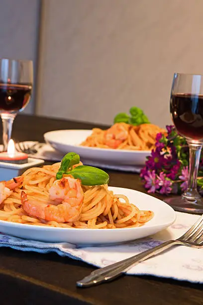Spaghetti in tomato sauce. Romantic dinner with wine and flowers, asters concept