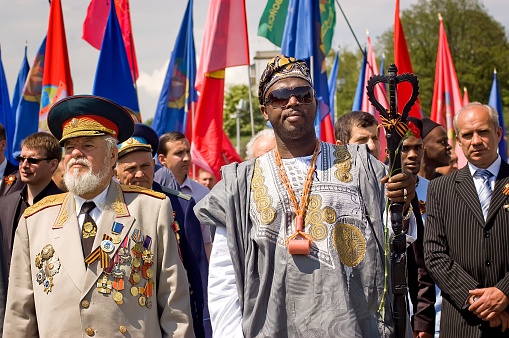 Kyiv, Ukraine - May 8, 2009: Senior Ukrainian officer and African man in traditional clothing stand in crowd during Victory Day celebration at the Museum of The History of Ukraine in World War II in Kyiv