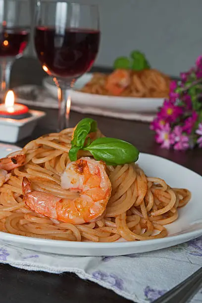 Spaghetti in tomato sauce. Romantic dinner with wine and flowers, asters concept