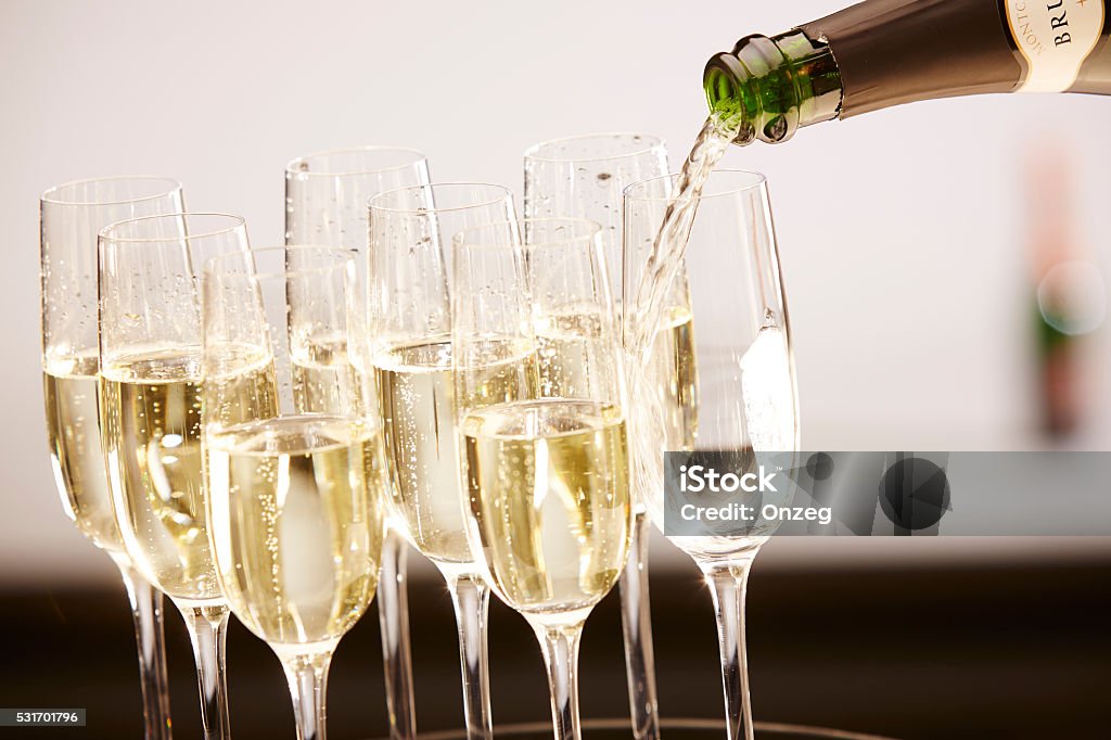 Glasses full of champagne on a tray Champagne drinks being poured on a tray Alcohol - Drink Stock Photo