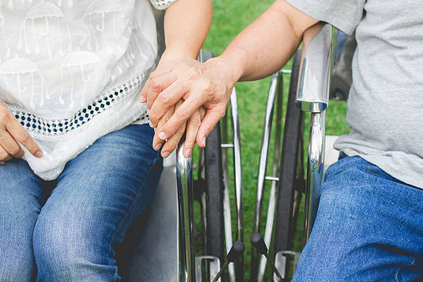 istock Hand holding hand on wheelchair, supporting care concept 531703096