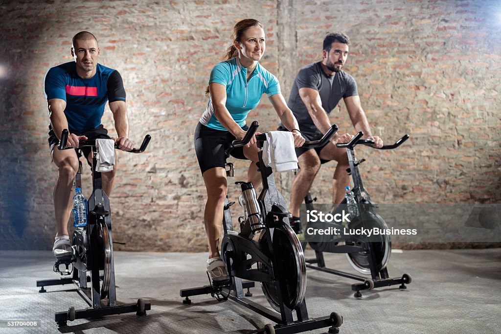 Young people cycling workout Young people cycling workout with rhythm of powerful music Spinning Stock Photo