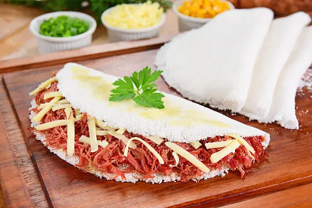 Typical Brazilian food made from cassava flour and filled with sun dried meat