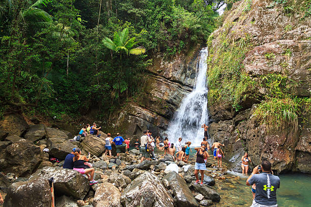 The Reality Anvil El Yunque, Puerto Rico - June 7, 2014: Realistic image of lots of tourists in the waterfall in the El Yunque forest in Puerto Rico, on June 7, 2014 el yunque rainforest stock pictures, royalty-free photos & images