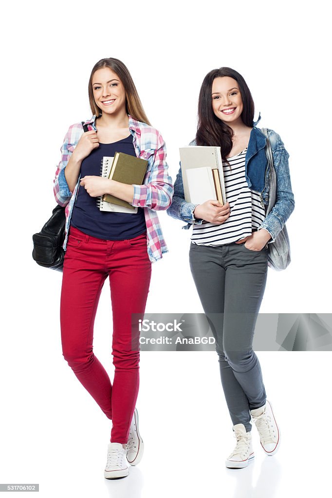 Happy student girls Young female students standing with books and bags, isolated on white Student Stock Photo