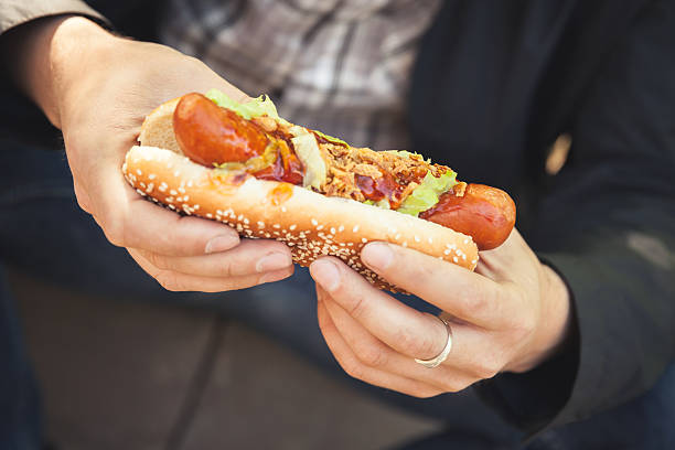 istock Man holds fresh hot dog in hands, closeup 531707984