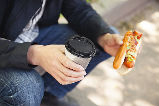 istock Man having lunch with hot dog and coffee 531708036