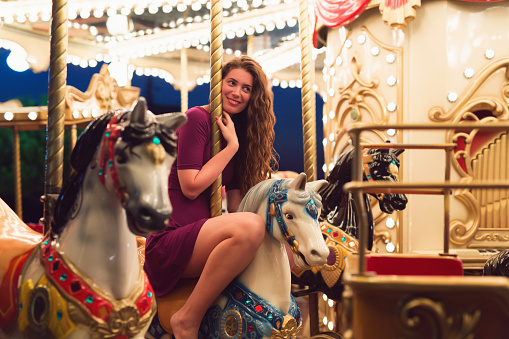 Beautiful caucasian girl at the carousel.