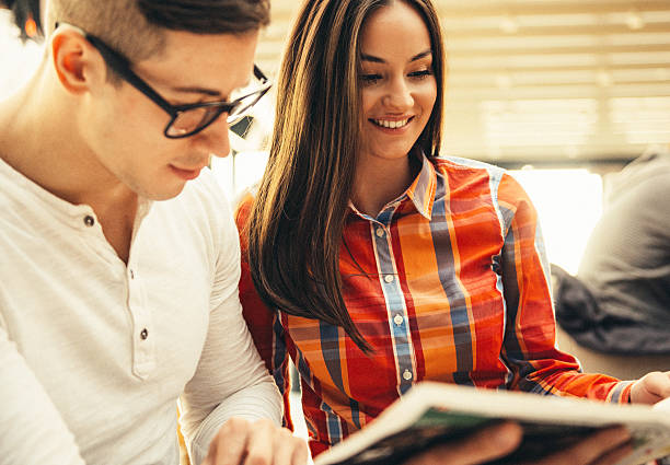 istock Young couple reading newspaper and drinking coffee in modern cafe 531708862