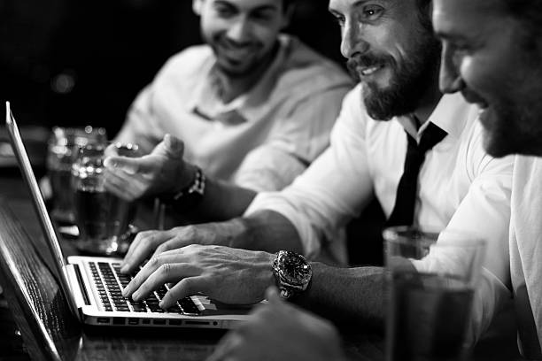 grupo de homens trabalhando em um computador portátil em um pub - professional occupation three people businessman human head - fotografias e filmes do acervo