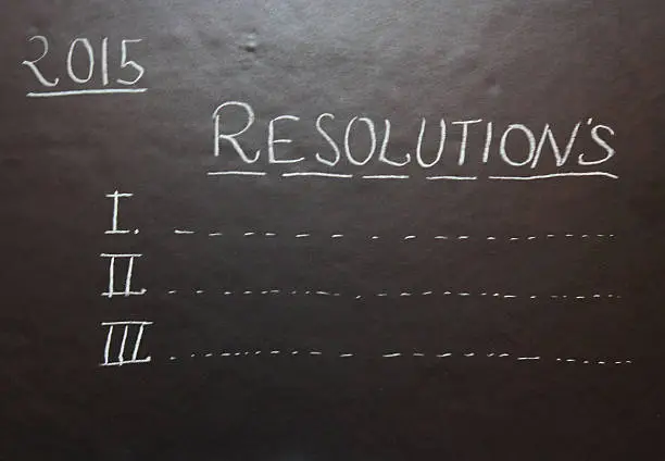 Resolutions in 2015 write with chalk on Blackboard. Educational or business growth activity.