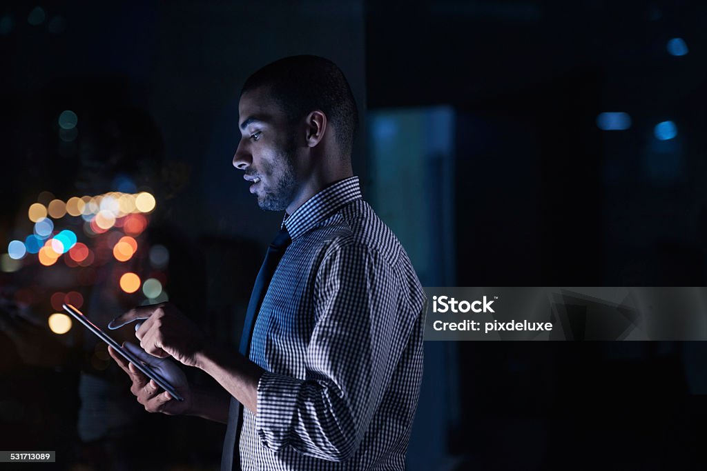 Work in silence, let success make the noise Shot of a young businessman using his digital tablet while working late http://195.154.178.81/DATA/istock_collage/0/shoots/784999.jpg Men Stock Photo