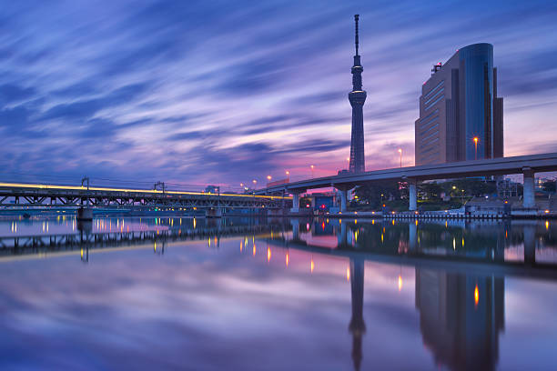 The Tokyo Sky Tree reflected in the Sumida River at sunrise.
