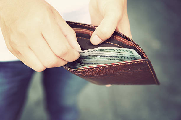 istock Hands taking  us dollars  out from wallet on the street 531714398