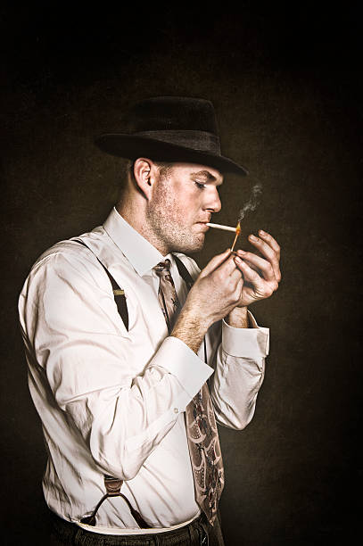 istock Vintage Man In Suspenders Hat and Tie Lighting A Cigarette 531715368