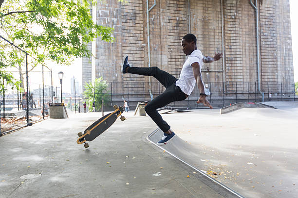 черный мальчик катание на коньках в парке и падать вниз - skate стоковые фото и изображения