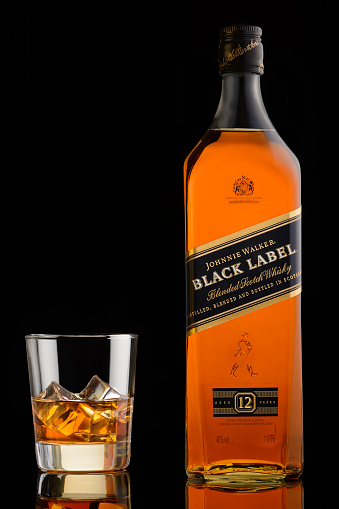 Moscow, Russia. May 13, 2016. Black label. Johnnie walker. Blended scotch whisky. 12 years. Bottle and glass with ice. Black background