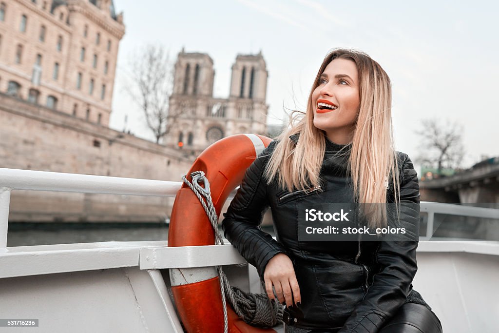 admiring Paris young and happy woman traveling in Paris, on Seine cruise, looking at beautiful capital of France. Paris - France Stock Photo