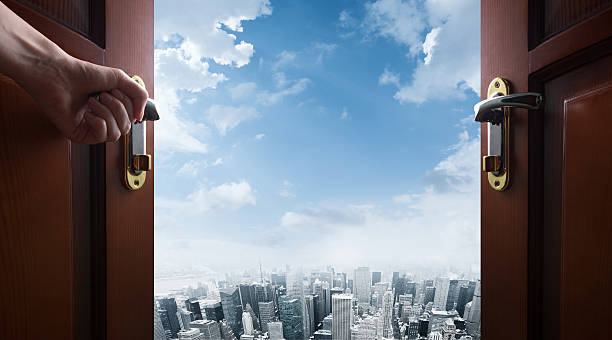 istock hand opens room door to the city 531716630