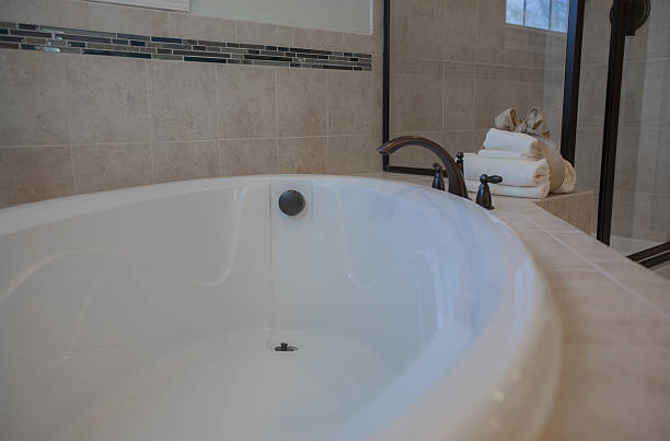 istock Clean white bath tub with shower in background 531721345