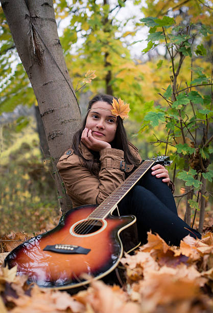 istock Meditative girl with a guitar in autumn 531724977