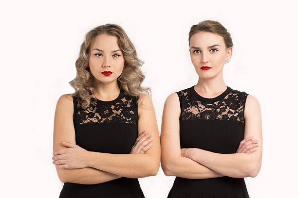 Two women in identical black dresses are angry at each other