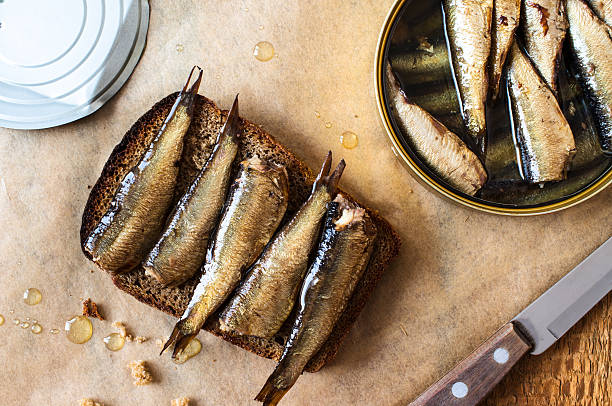 Sandwich with sprats Sandwich with sprats on a table with a can of sprats kipper stock pictures, royalty-free photos & images