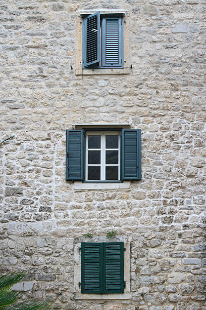 Windows with shutters in the three storey building. vertical