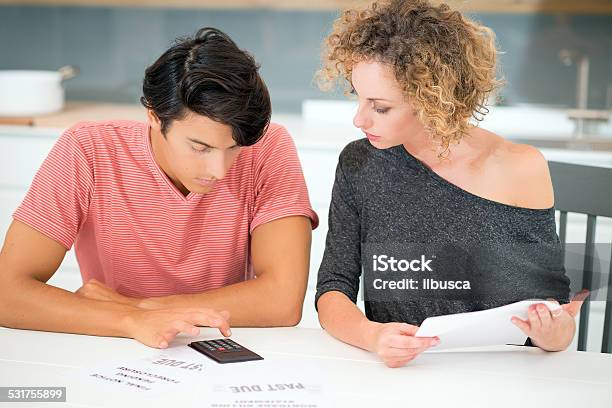 Couple With Bills Stock Photo - Download Image Now - 20-29 Years, 2015, 30-39 Years